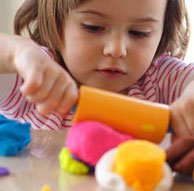 Little girl rolling playdough
