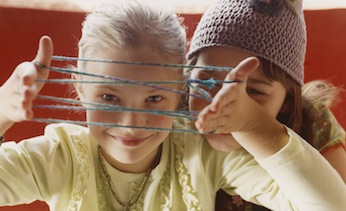 two girls doing string tricks
