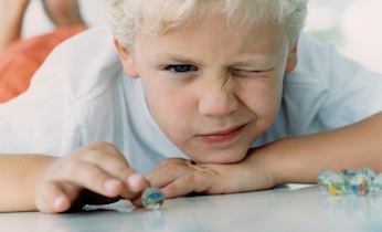 little boy playing with marbles