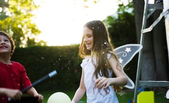 two kids with wands under confetti